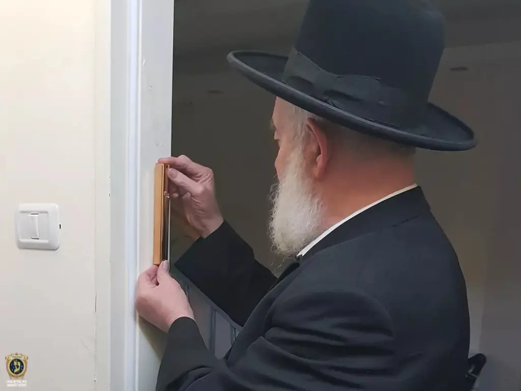 הרב יצחק כהן בקביעת מזוזה במשרדי מכון עליה